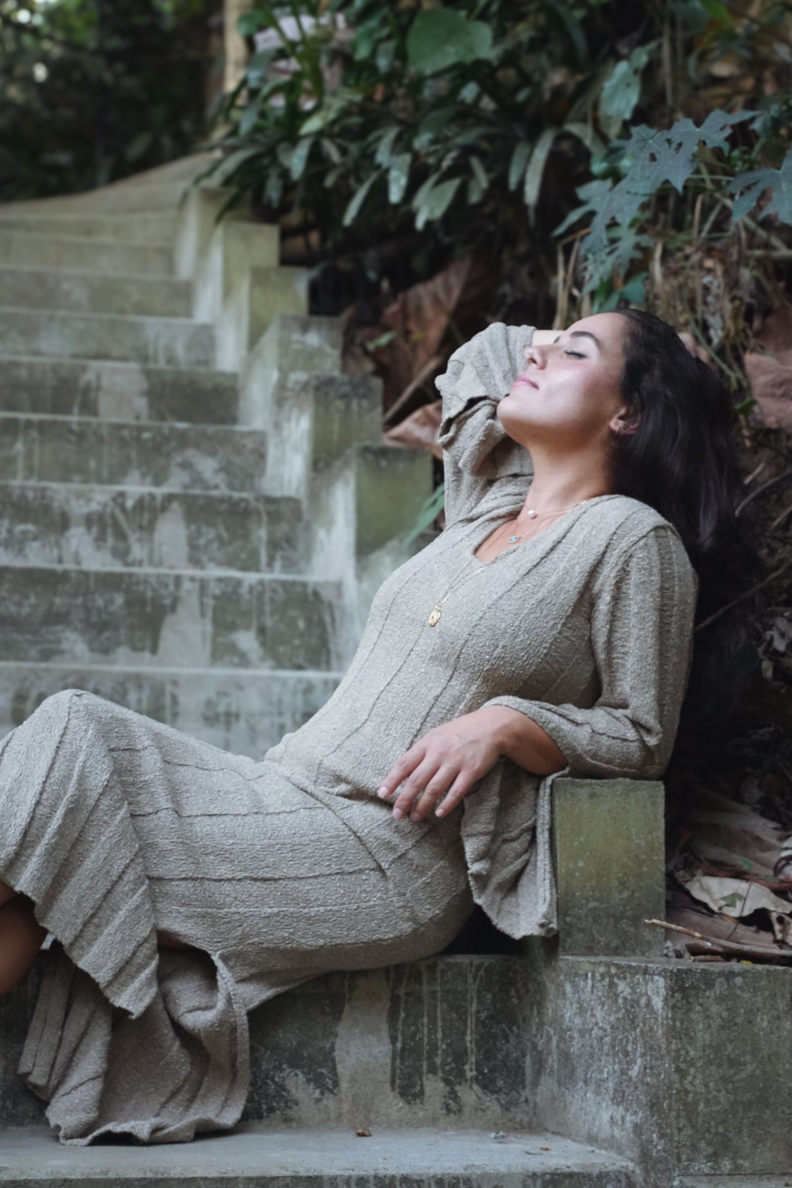 Tima Rasekh resting on garden steps, face to the sun